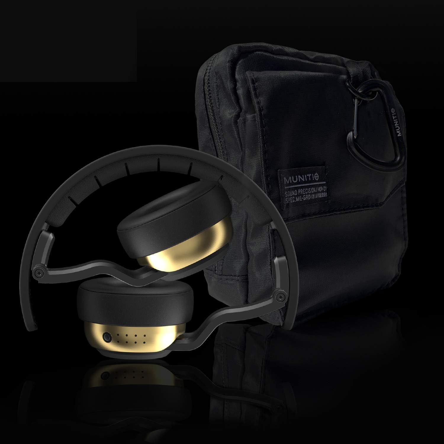 Black and gold headphones with a black bag on a reflective surface